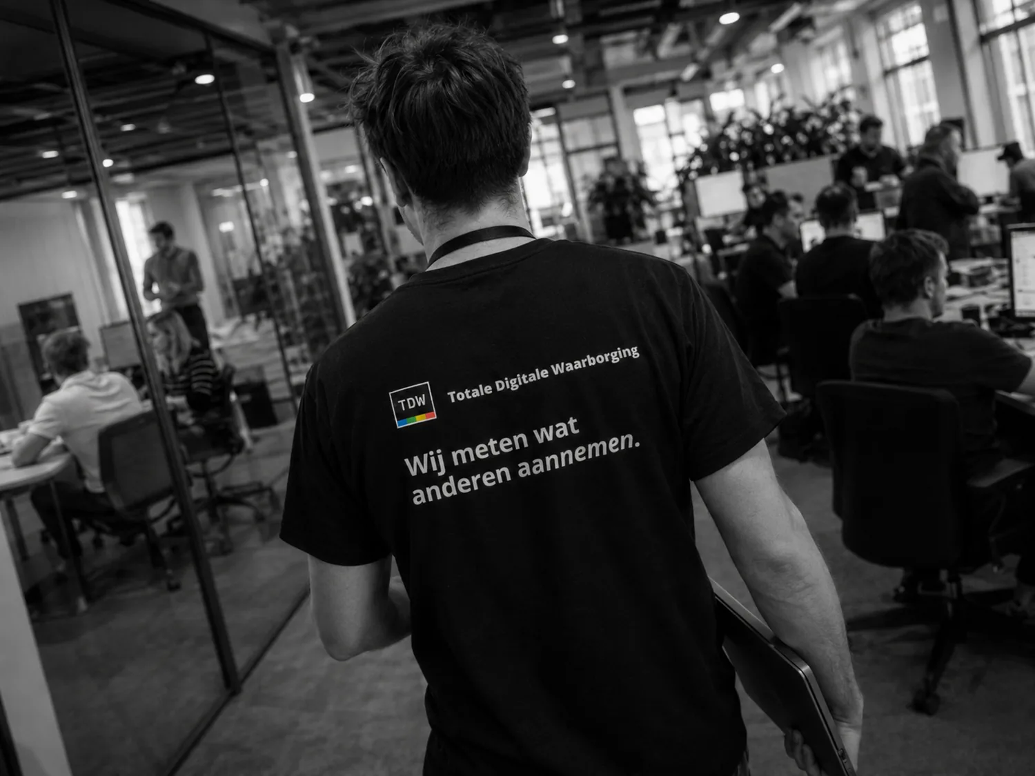 Iemand in een Totale Digitale Waarborging-shirt op een werkvloer